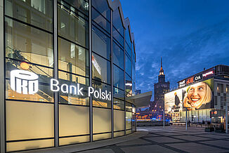 La Bank Polski éclairée dans le bâtiment à usage mixte Rotunda et d'autres bâtiments commerciaux à Varsovie la nuit.