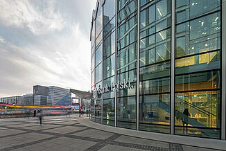 La Bank Polski dans le bâtiment à usage mixte Rotunda à Varsovie, avec vue sur d'autres bâtiments résidentiels et commerciaux et sur la rue.