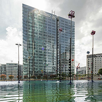 Le quartier de bureaux de La Défense à Paris avec la tour Allianz One et un étang devant.