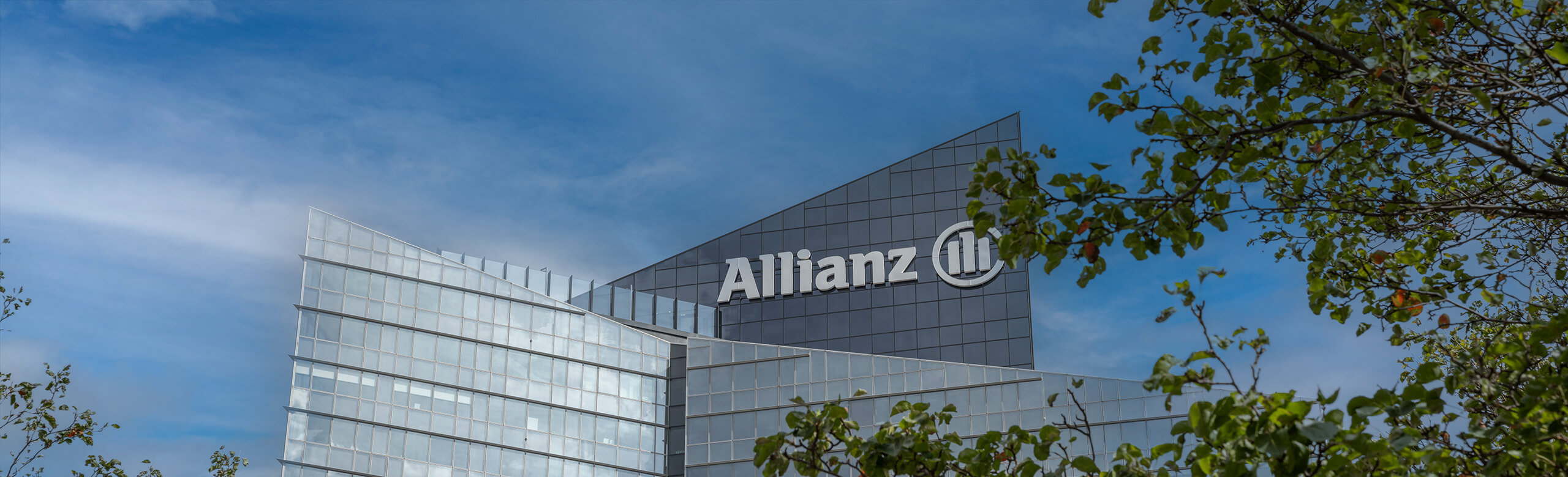 Exterior view of the upper floors of the Allianz One Tower in Paris with the Allianz logo at the top of the tower.